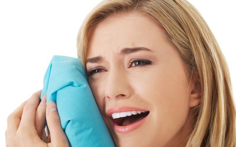Bạn có thể chườm đá lạnh để giảm bớt cảm giác đau nhức sau khi nhổ răng số 8