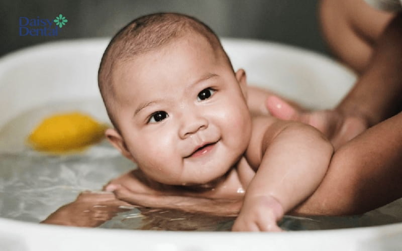 Nếu trẻ sốt mọc răng, bố mẹ vẫn nên tắm bằng nước ấm cho con