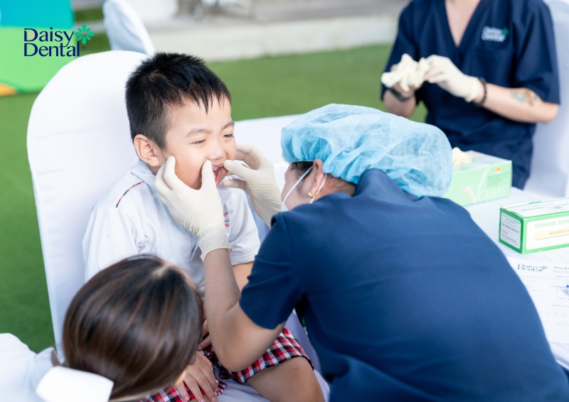 Các em học sinh được bác sĩ thăm khám và hướng dẫn chăm sóc răng miệng đúng cách