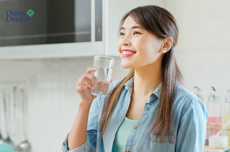 Bạn nên uống nước thường xuyên để giúp răng sạch vụn thức ăn, mảng bám